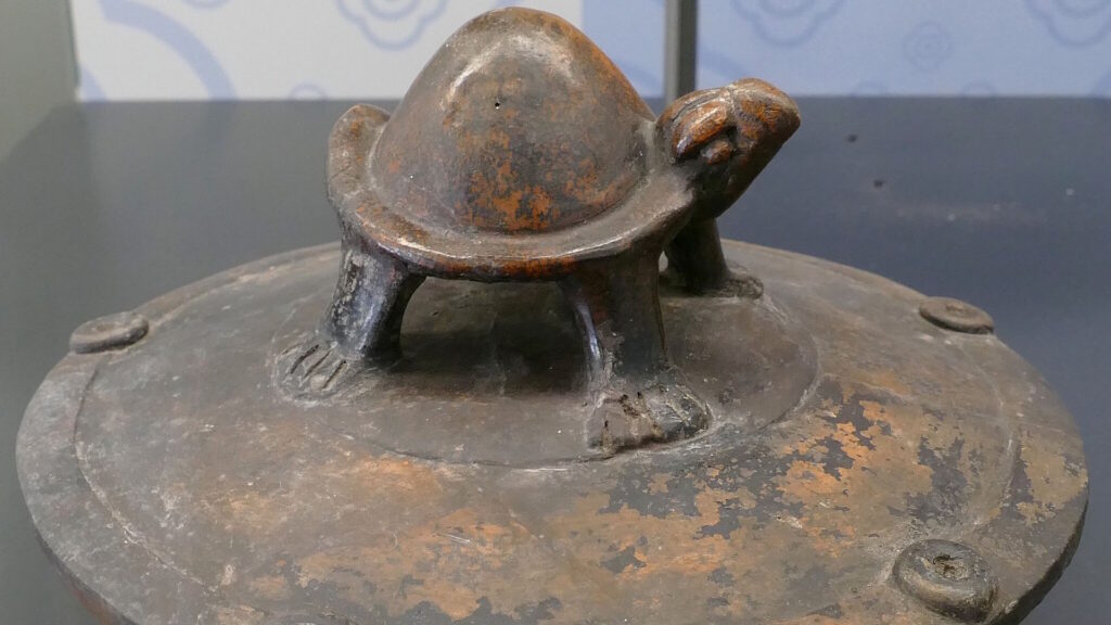 ceramic pot lid featuring a sculpted turtle on top, with worn surfaces and a patina consistent with ancient artifacts; from the Maya civilization.