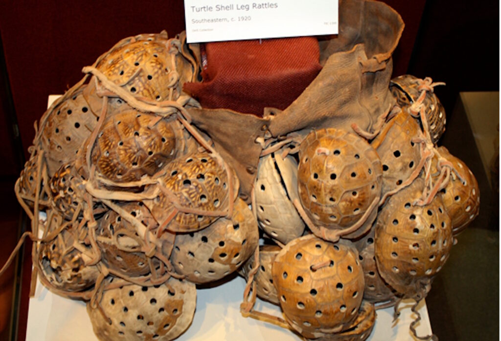 A display of Native American turtle shell leg rattles tied with cords, used in ceremonial dances.